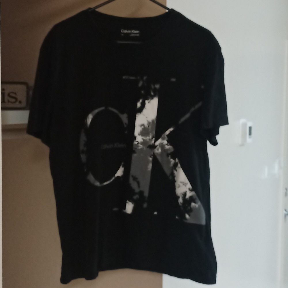 Black Calvin Klein shirt with black and white camouflage lettering.